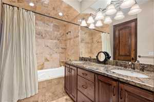 Bathroom featuring double sink, shower / bath combo, tile floors, and oversized vanity