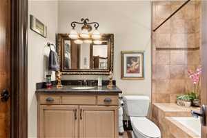 Bathroom featuring a chandelier, vanity, and toilet
