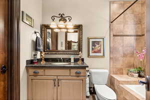 Bathroom featuring a chandelier, vanity, and toilet