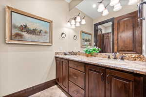 Bathroom with dual bowl vanity and tile flooring