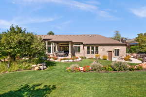 Rear view of house featuring a patio area and a yard