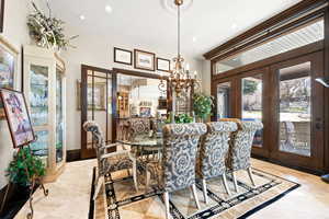 Tiled dining space with a chandelier and french doors