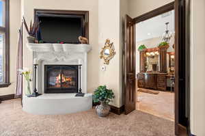 Living room with light colored carpet and a notable chandelier