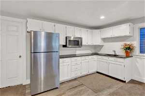 Downstairs kitchen featuring white cabinets and stainless steel appliances