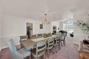 Dining space featuring crown molding, carpet, and a chandelier
