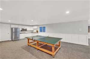 Game room with light carpet and sink