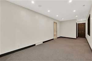 Spare room featuring dark colored carpet