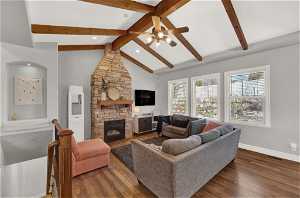 Living room w/ gas fireplace + exposed beams / vaulted ceilings.