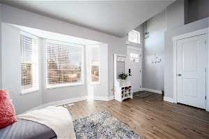 Living area featuring plenty of natural light, lofted ceiling, and dark hardwood / wood-style flooring