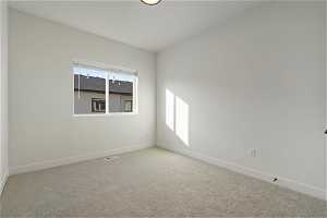Unfurnished room featuring light carpet and a wealth of natural light