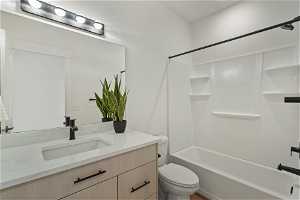 Full bathroom featuring toilet, vanity, and shower / bathing tub combination