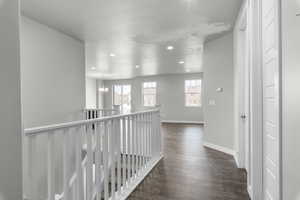 Hallway with a chandelier and dark hardwood / wood-style floors