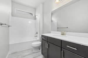 Full bathroom with hardwood / wood-style floors, vanity, shower / tub combination, and toilet