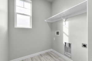 Laundry room featuring electric dryer hookup, washer hookup, and light hardwood / wood-style floors