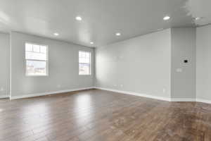 Empty room with dark hardwood / wood-style flooring