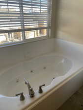 Bathroom featuring a bathing tub, tile flooring, and a wealth of natural light