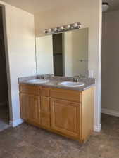 Bathroom with dual vanity and tile flooring