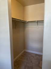 Walk in closet with dark carpet