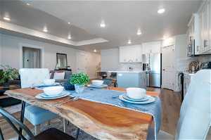 Dining space with a tray ceiling, sink, and hardwood / wood-style flooring
