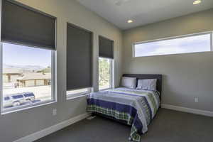 Bedroom featuring dark colored carpet and ceiling fan