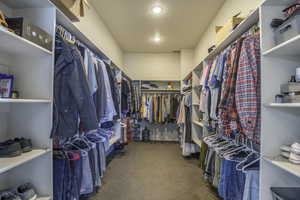 Walk in closet featuring dark colored carpet