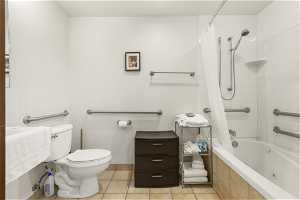 Bathroom with shower / bath combo, tile flooring, and toilet