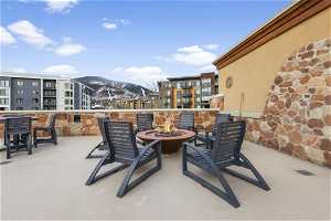 View of terrace with a balcony, a fire pit, and a mountain view