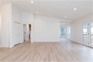 Unfurnished room featuring lofted ceiling and light hardwood / wood-style floors