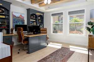 Office area featuring ceiling fan, beamed ceiling, and light hardwood / wood-style floors
