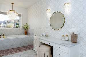 Bathroom featuring tile floors, vanity, a chandelier, and tiled bath