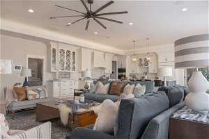 Living room with ceiling fan with notable chandelier