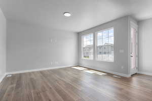 Empty room featuring a textured ceiling and light wood-type flooring