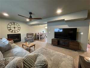 South unit Carpeted living room with a textured ceiling and ceiling fan
