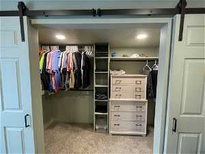 South unit Spacious closet with a barn door and carpet floors