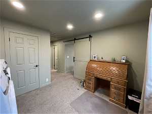 South unit Carpeted home office featuring a barn door