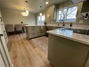 South unit Kitchen featuring pendant lighting, sink, kitchen peninsula, light hardwood / wood-style floors, and dishwasher