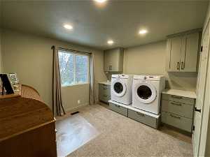 South unit Clothes washing area with cabinets, light carpet, and washing machine and dryer