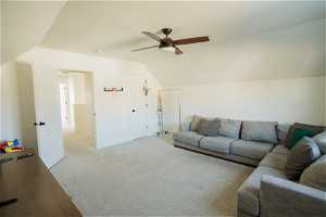 Living room with vaulted ceiling, light carpet, and ceiling fan