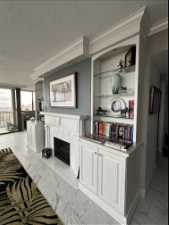 Tiled living room with crown molding, and fireplace