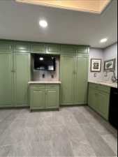 Kitchen featuring cabinets, sink, and light tile flooring