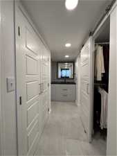 Hall  to walk-in closet featuring light tile flooring in Primary Bath