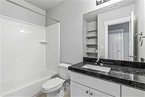 Basement bathroom with bathtub / shower combination, tile flooring, oversized vanity, and toilet