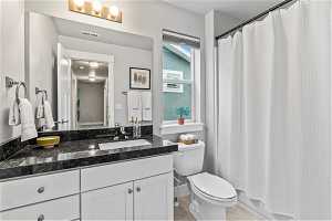 Shared full bathroom with tile flooring, and vanity with extensive cabinet space