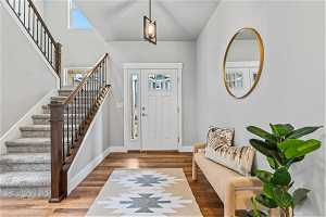 Looking back at the entryway with high vaulted ceiling and dark hardwood / wood-style floors