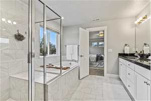 Primary bathroom with plus walk in shower, a textured ceiling, tile floors, and oversized vanity