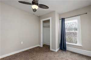 Unfurnished bedroom featuring a closet, light colored carpet, and ceiling fan