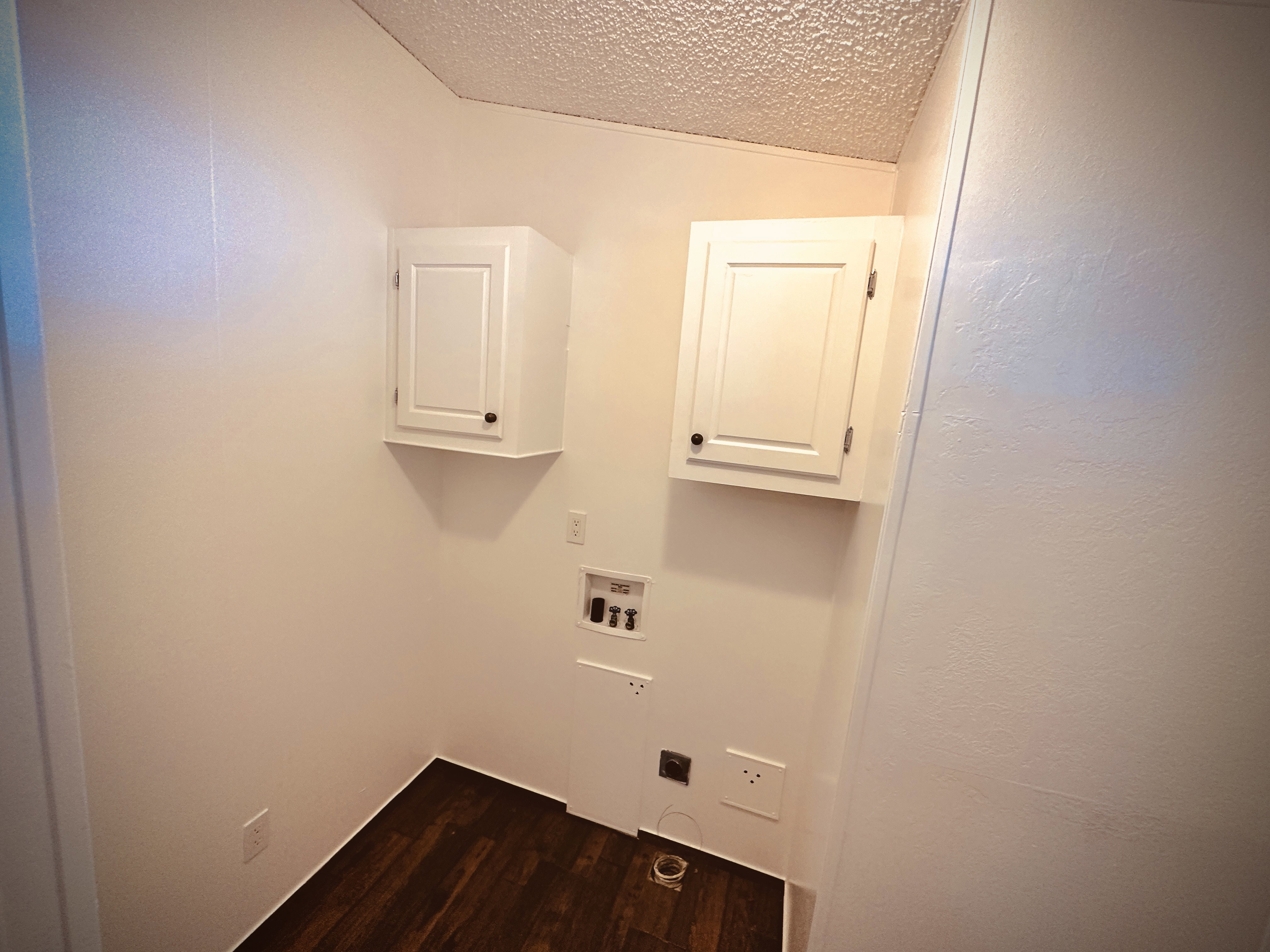 Washroom featuring cabinets, washer hookup, a textured ceiling, dark wood-type flooring, and hookup for an electric dryer