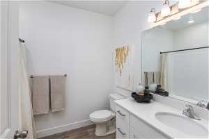 Bathroom 2 featuring vanity, toilet, and hardwood / wood-style flooring