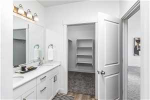 Primary Bathroom with double sink, oversized vanity, and hardwood / wood-style flooring