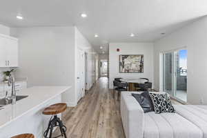 Interior space with access to outside, sink, and light hardwood / wood-style floors